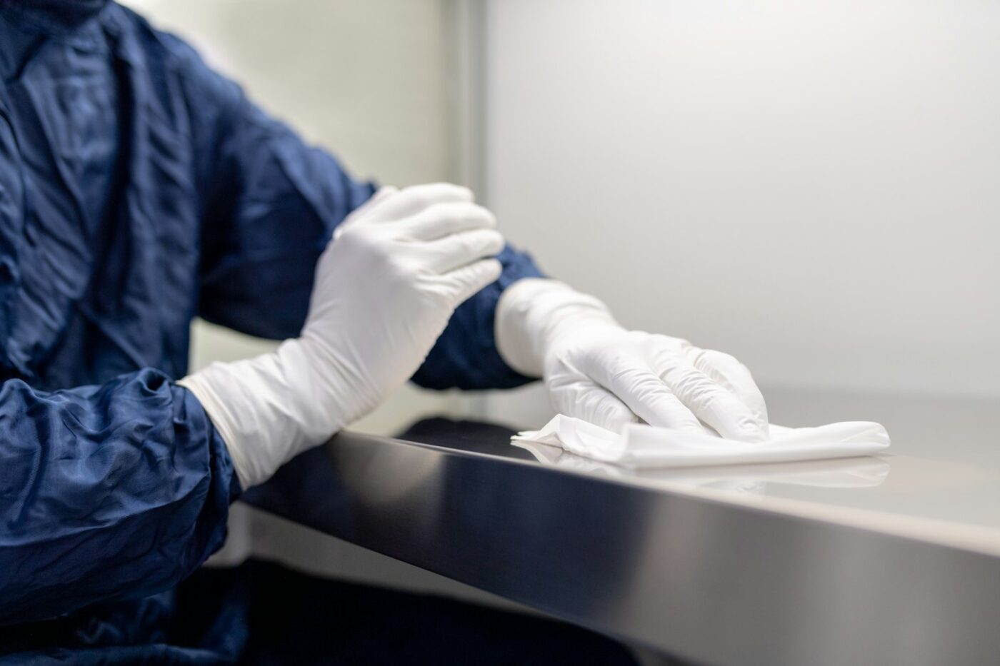 Medewerker van een ziekenhuisapotheek werkt met handschoenen in een veiligheidswerkbank