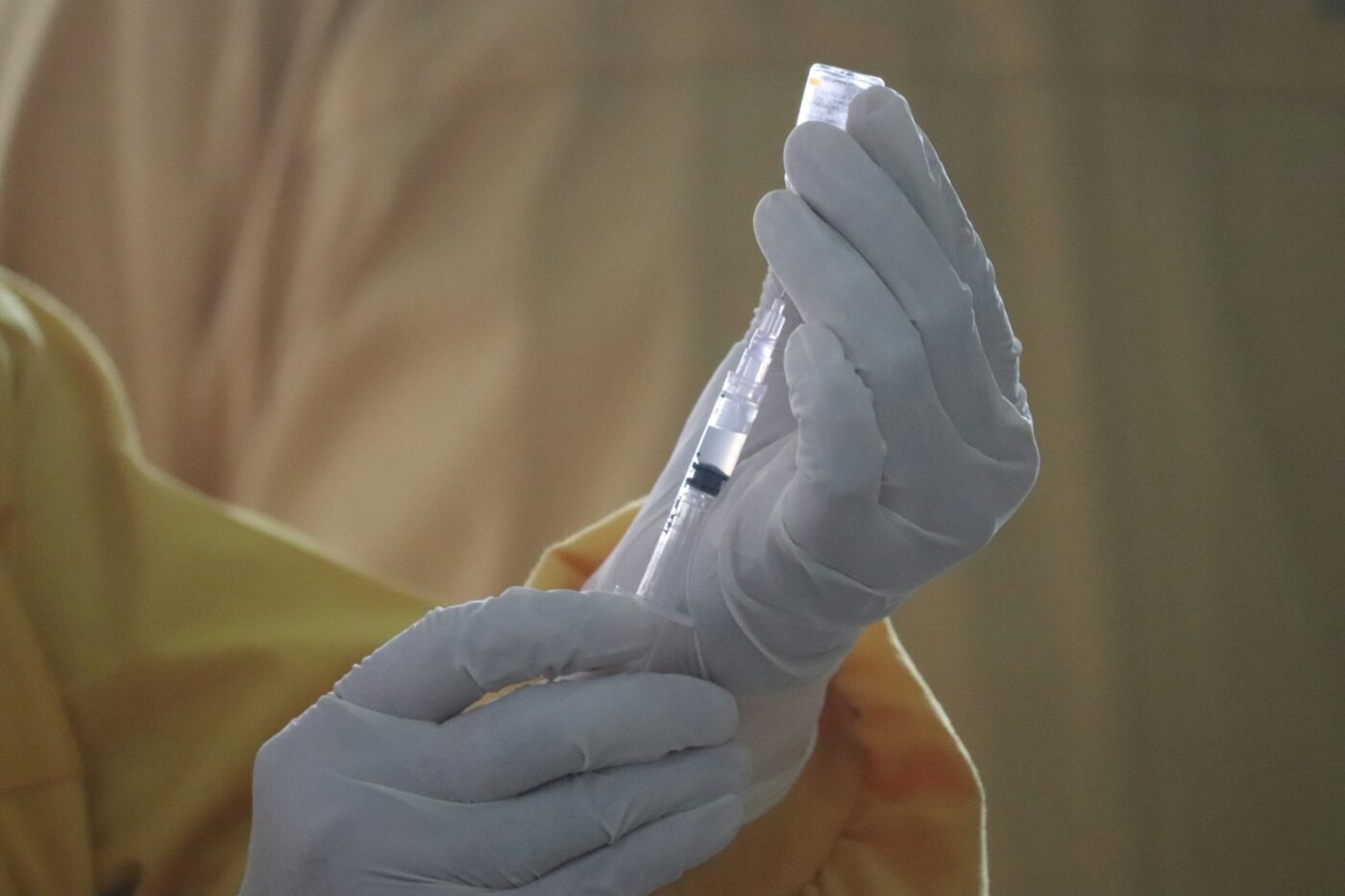 Zorgmedewerker bereidt een vaccinatie voor in een behandelkamer