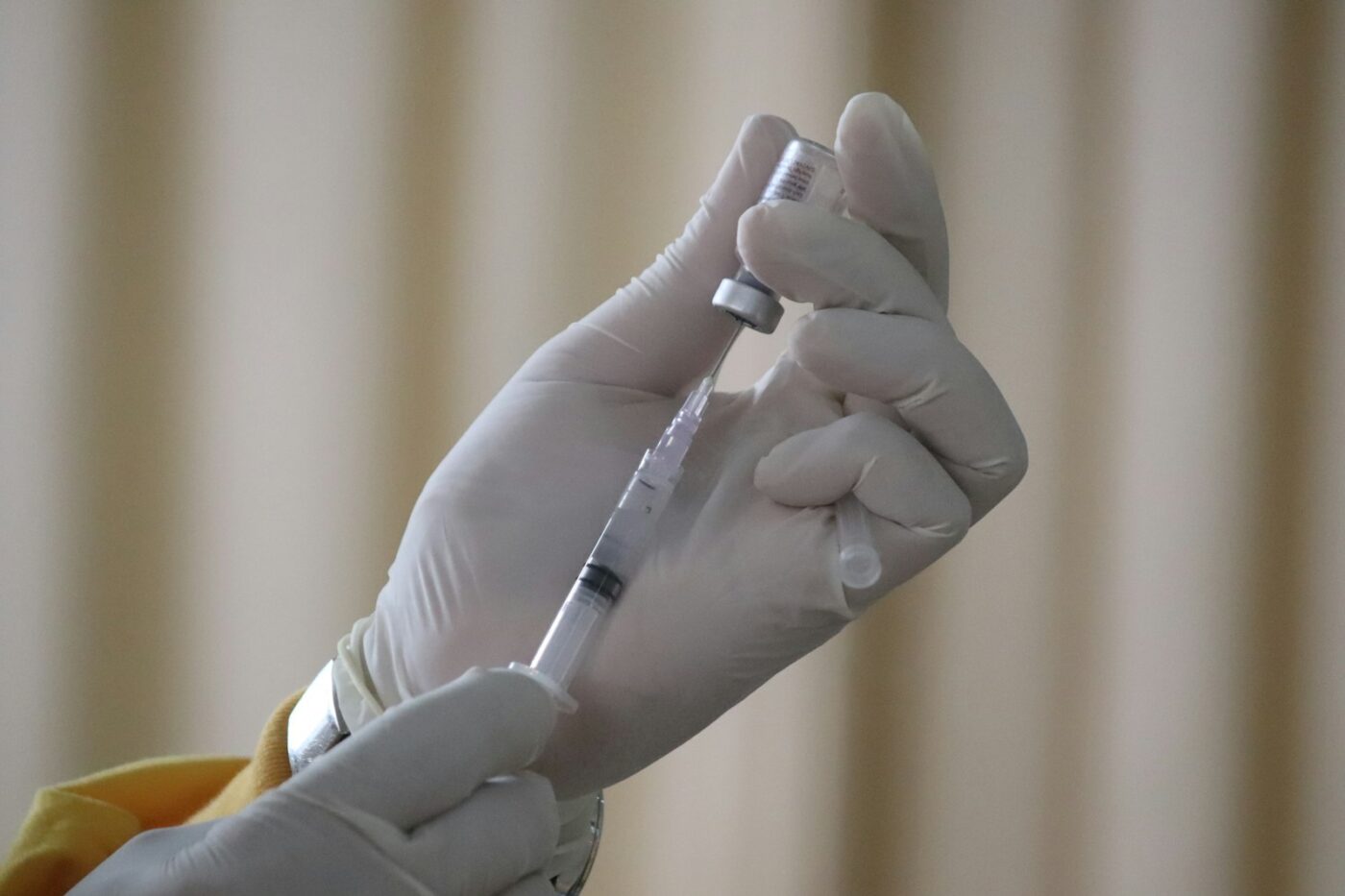 Verpleegkundige bereidt een griepvaccinatie voor in een behandelkamer