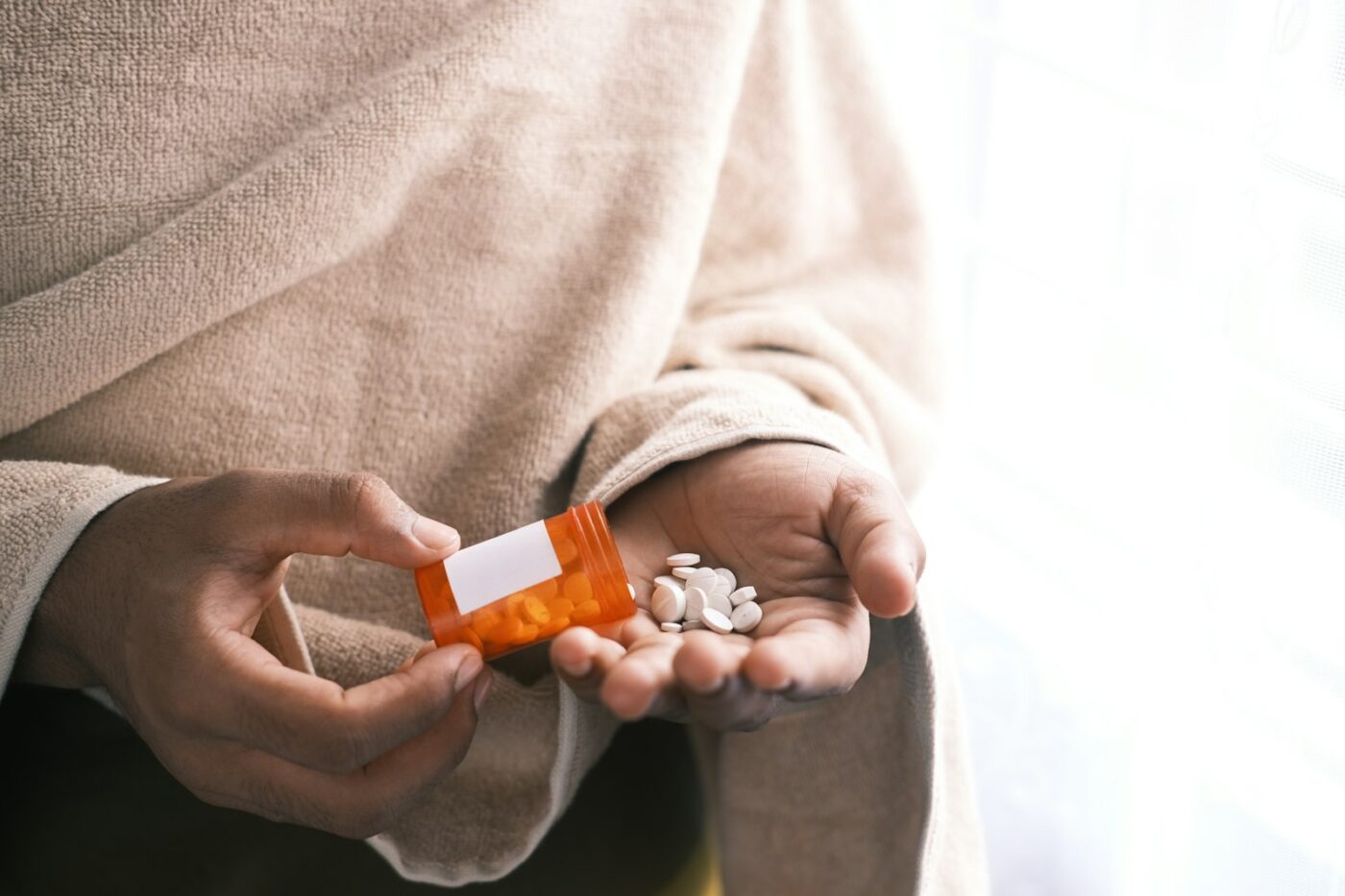 Zorgmedewerker reikt een bewoner medicijnen aan in een verpleeghuis