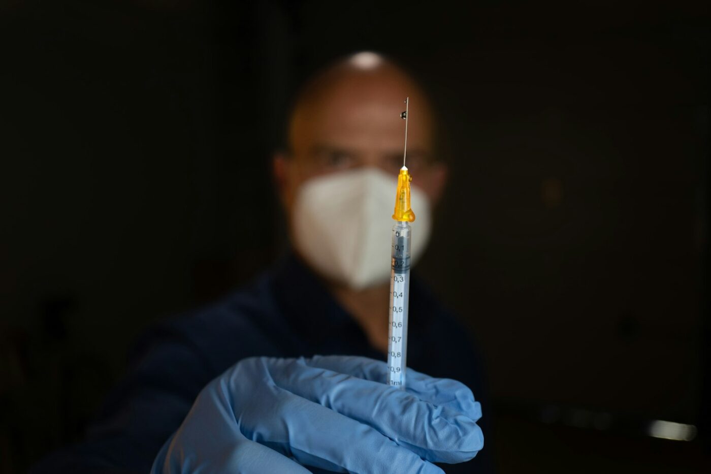 Injectiespuit op een blauwe ondergrond in een zorgomgeving