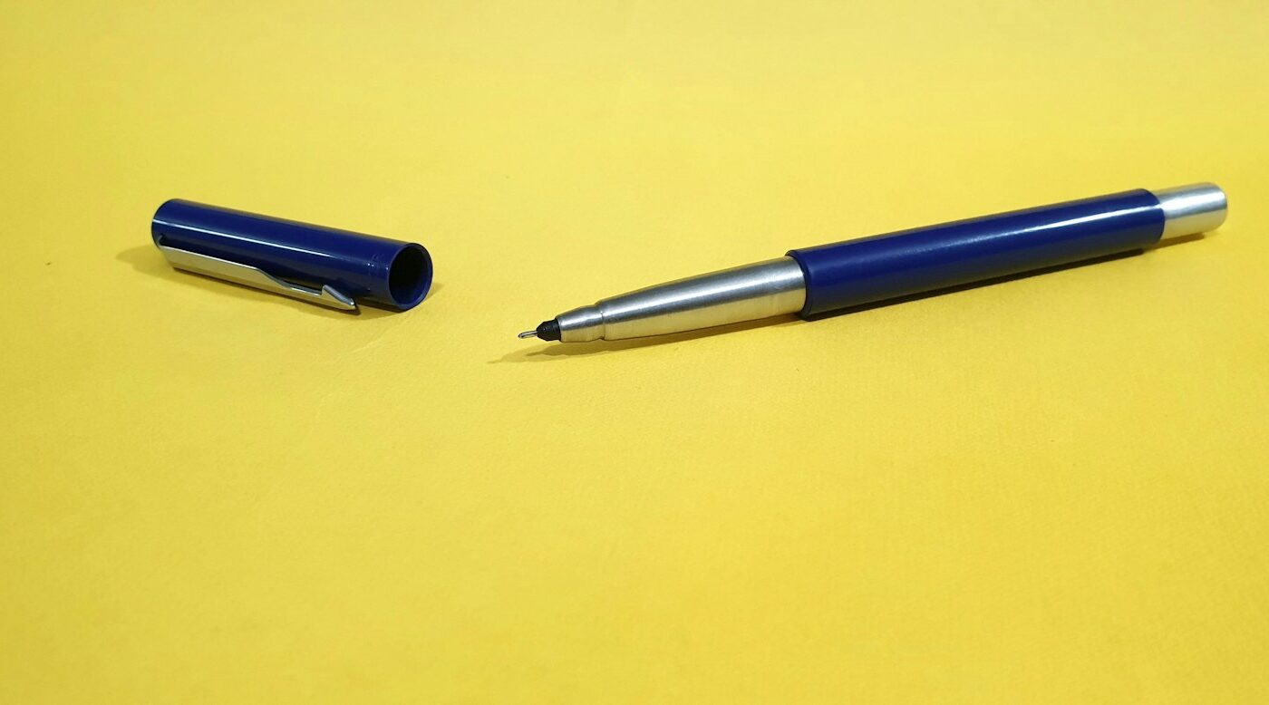 Formulier en pen op een bureau naast een laptop