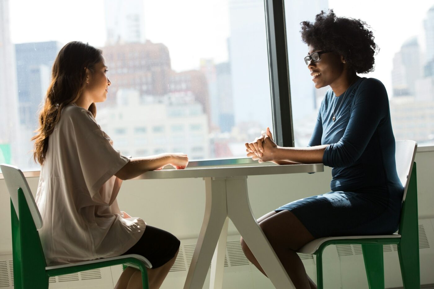 Zorgmedewerker in een rustig gesprek met een vertrouwenspersoon aan tafel