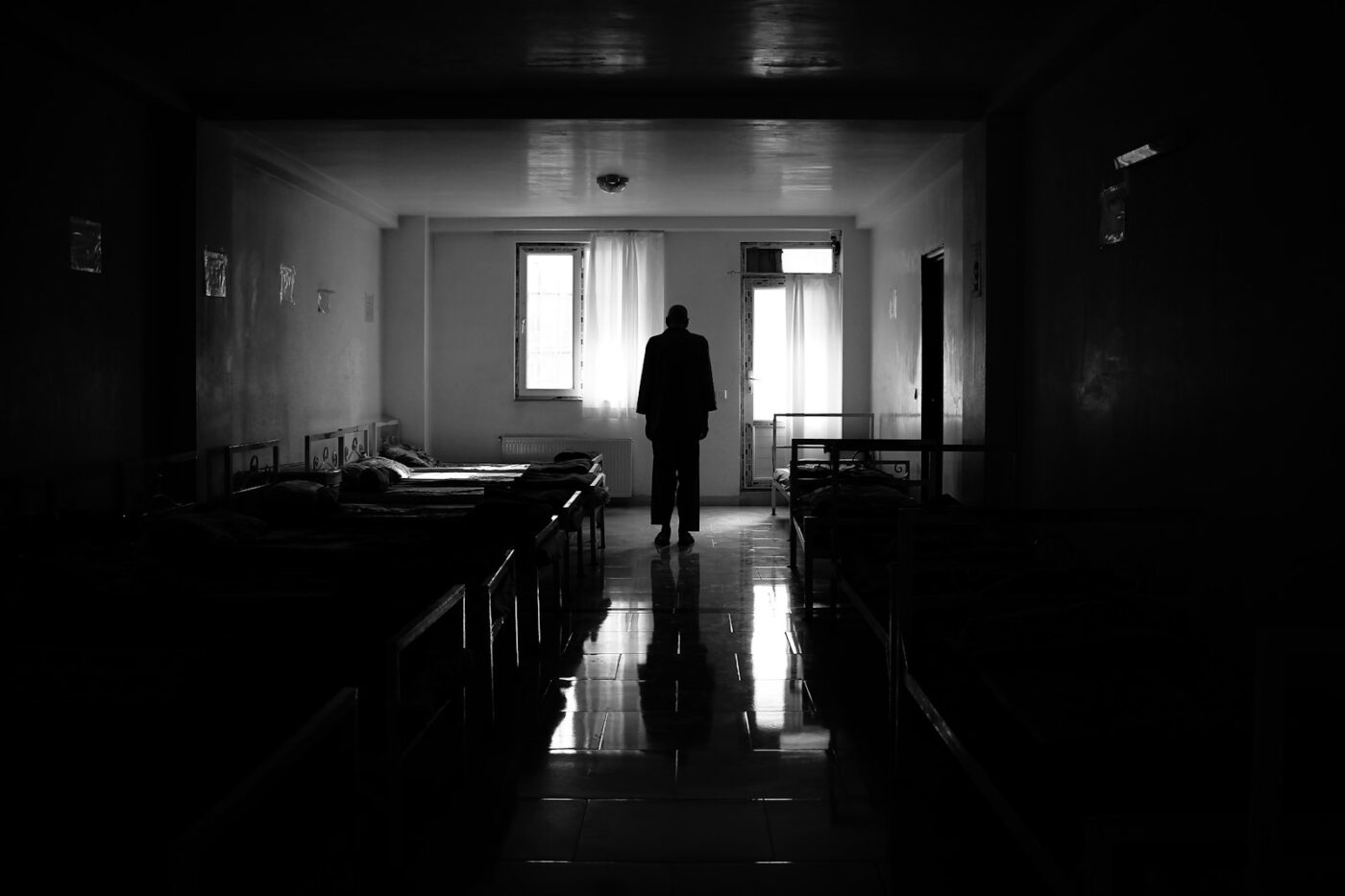 Verpleegkundige trekt handschoenen aan bij een isolatiekamer