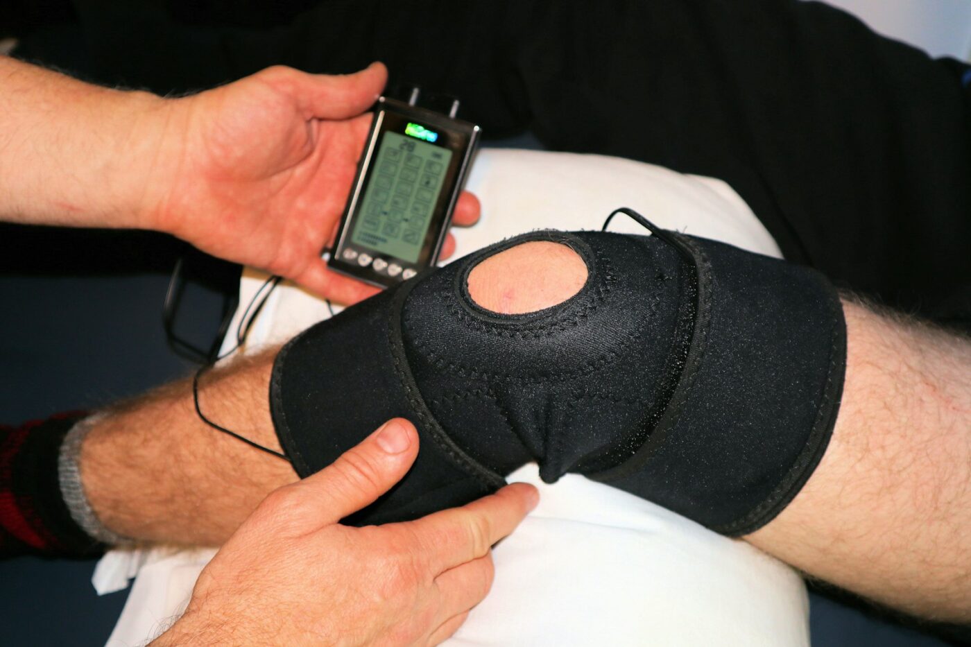 Arts bekijkt een röntgenfoto van een knie op een beeldscherm