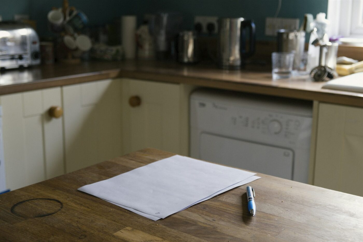 Zorgverlener bespreekt papieren met een cliënt aan de keukentafel