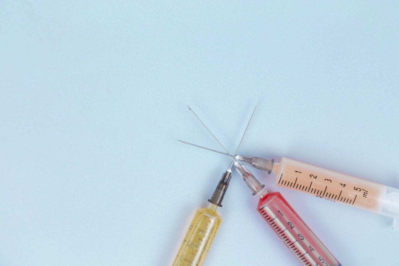 Injectiepen en spuit op een tafel naast een medicijndoosje
