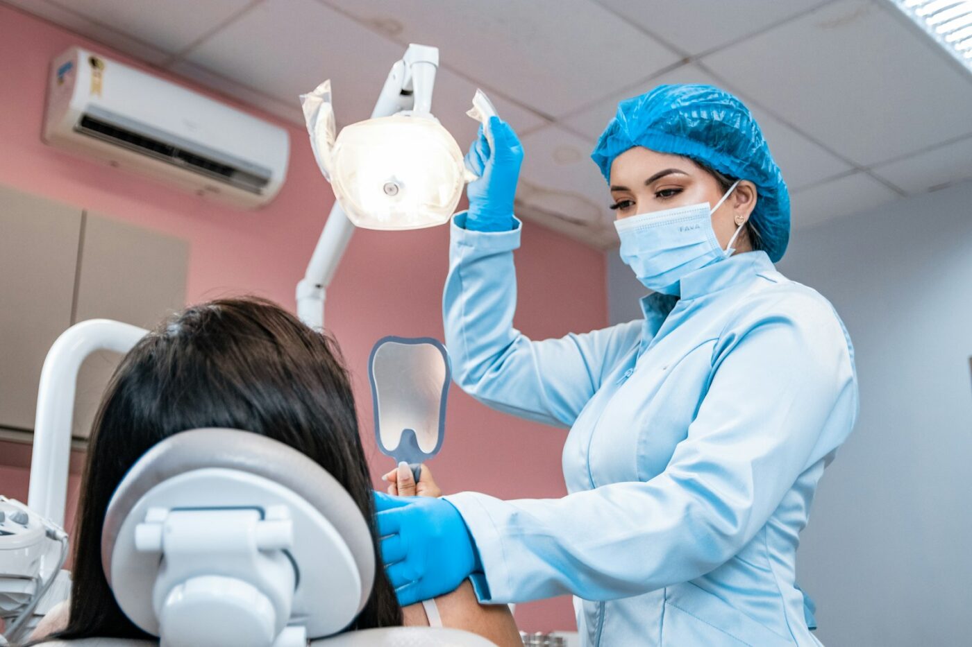 Mondhygiënist behandelt een patiënt in de behandelstoel van een mondzorgpraktijk