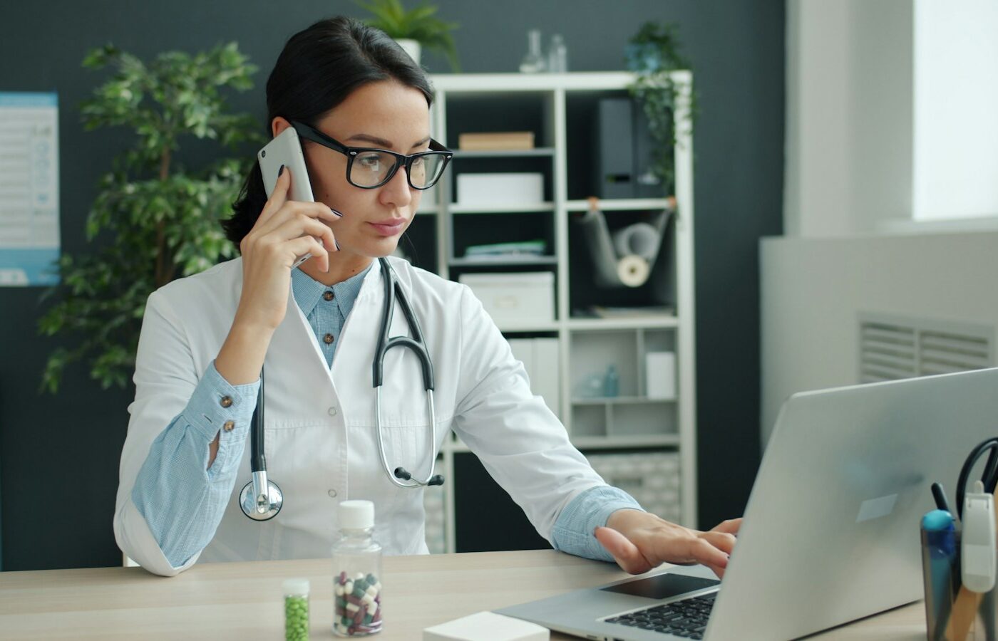 Zorgverlener zoekt een registratie op aan een bureau met laptop
