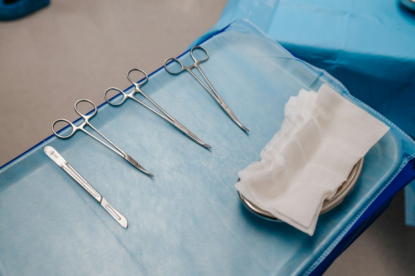 Steriele hechtset met naaldvoerder en pincet op een behandeltafel
